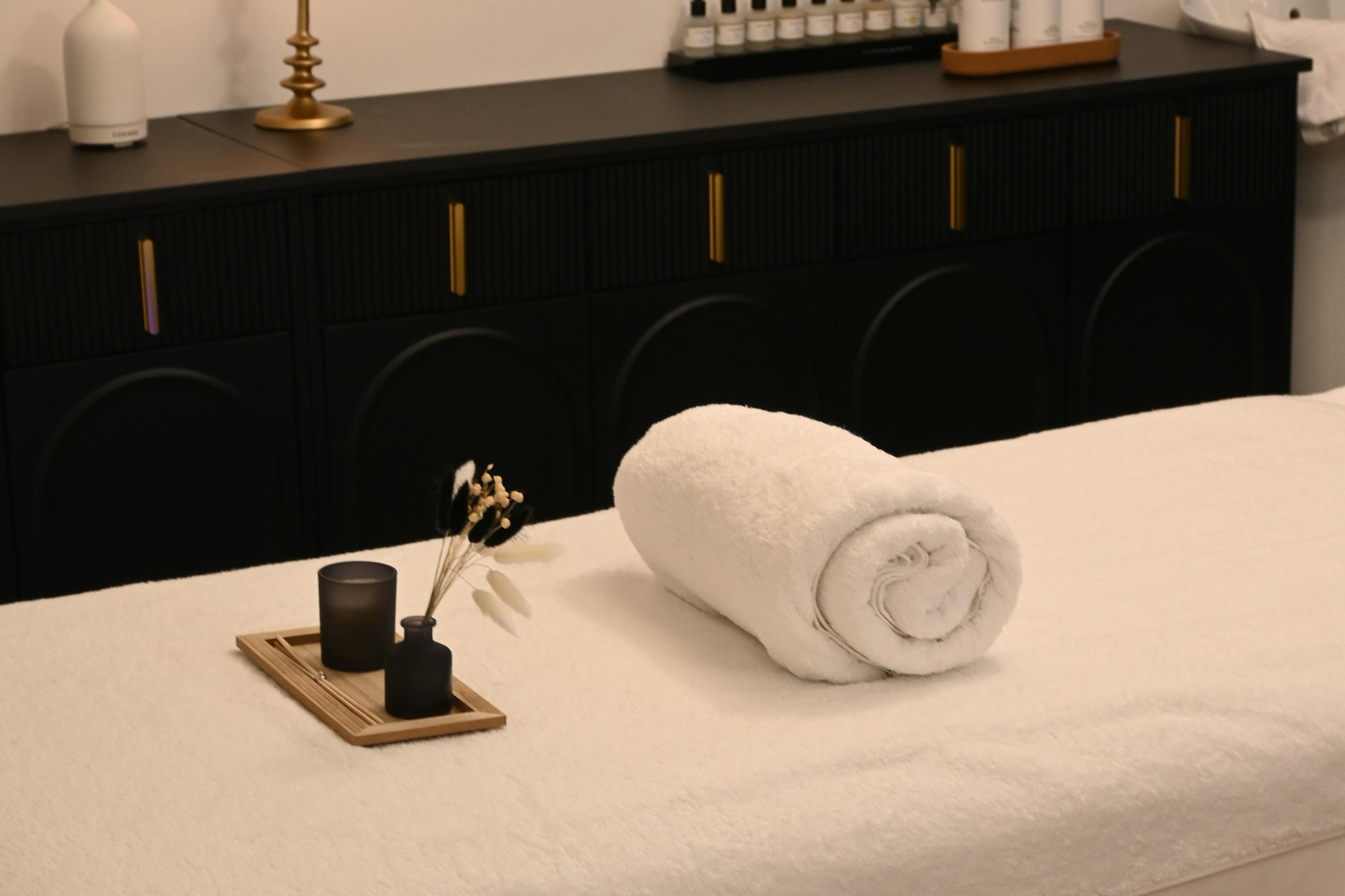 Elegant massage treatment room with warm candlelight and fresh towels
